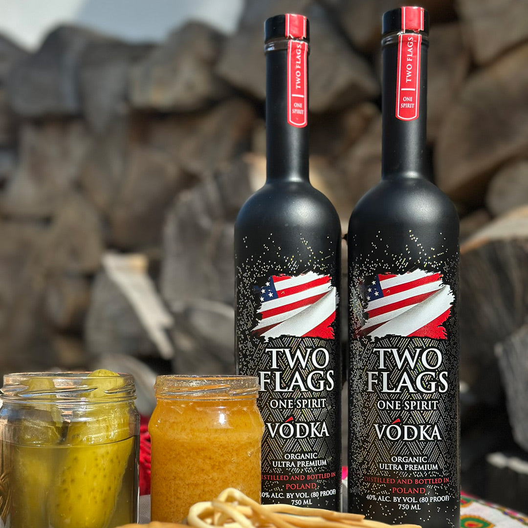 Two Flags One Spirit Vodka bottles with organic pickles on a rustic background. Ultra-Premium Organic Vodka